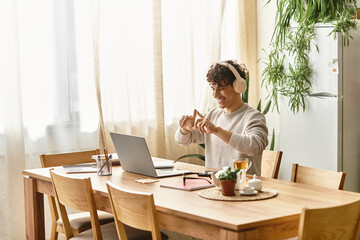 Stylish young man working from home while engaged in a virtual meeting with cheerful demeanor