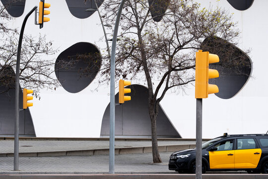 Traffic lights in front of a modern white building with circular windows, highlighting contrast, geometry, and the fusion of urban signals with contemporary architecture.