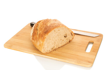 One half of a hearth bread on a bamboo board isolated on a white background, close-up.