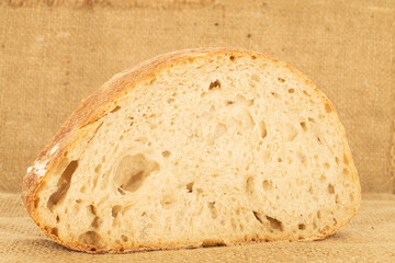 One piece of hearth bread on jute cloth, close-up.