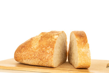 One half of a hearth bread on a bamboo board isolated on a white background, close-up.