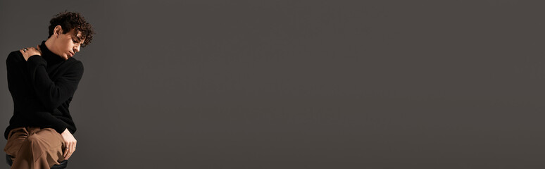 Stylish young man displaying confidence in a minimalist urban setting