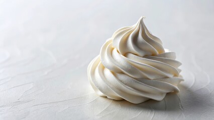 A dollop of whipped cream settles on a plain white surface