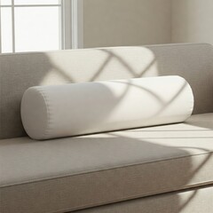 Neutral beige sofa with white cylindrical bolster pillow and sunlight shadows