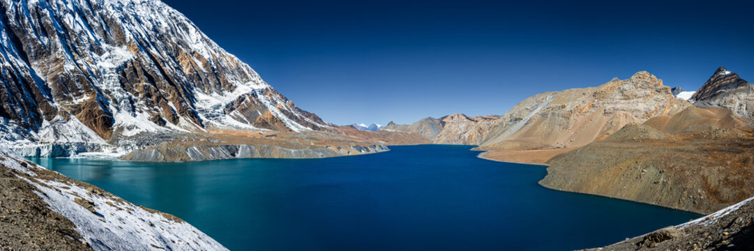 Tilicho lake with bright blue water in calm weather in autumn sunny day. Panoramic view. A sacred to Buddhists and Hindus lake in Himalaya mountain in Annapurna area, Nepal.