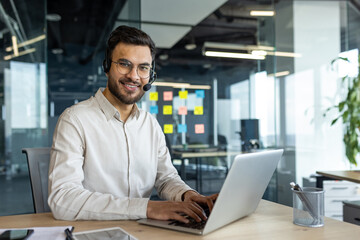 Portrait of young successful company employee with headset. Online customer support consultant...