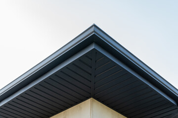 The sleek lines of a modern roof reveal sharp angles and a minimalist design, set against a clear...
