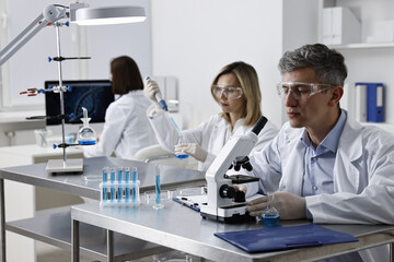 Scientists working with samples at table in laboratory