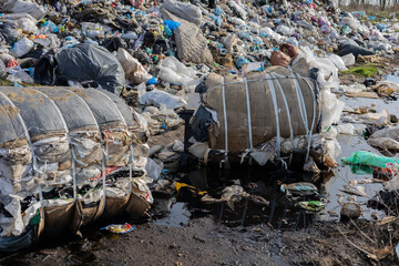Large piles of waste and discarded materials fill the landscape, highlighting the pressing issue of...