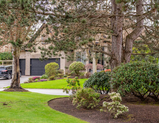 Two story stucco luxury house with nice spring blossom landscape in Vancouver, Canada, North America. Day time on April 2025