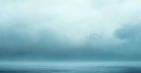 A moody seascape with a low hanging, misty sky. The calm water reflects the muted blues and grays of the overcast atmosphere. Minimalist, serene, and atmospheric.