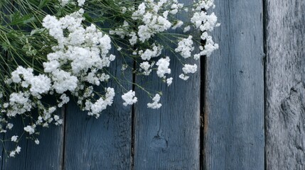 A collection of delicate white wildflowers is thoughtfully arranged on a weathered black wooden surface, providing a rustic yet elegant touch with ample copy space