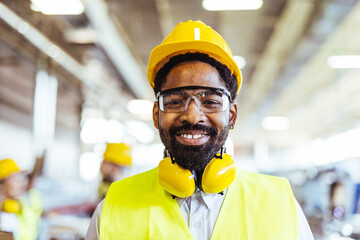 Smiling Worker in Protective Gear at an Industrial Workplace