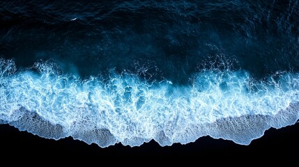 Ocean waves crashing on a black shore