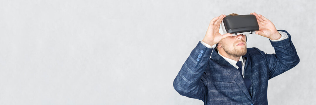 Banner, Portrait of a serious business man with virtual reality glasses on his head. On a light background.