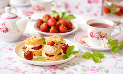 Cream puffs cakes or profiterole filled with whipped cream and strawberries
