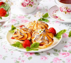 Cream puffs cakes or profiterole filled with whipped cream and strawberries