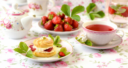 Cream puffs cakes or profiterole filled with whipped cream and strawberries