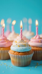 Close up of colorful cupcakes with lit candles and sprinkles on blue background, Birthday Celebration.