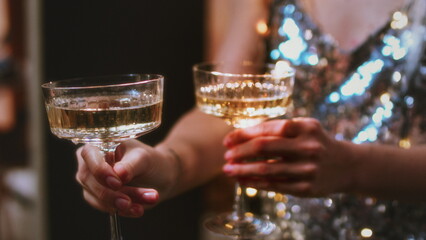 A beautiful girl holds glasses of champagne in her hands. Le coup cocktail glasses
