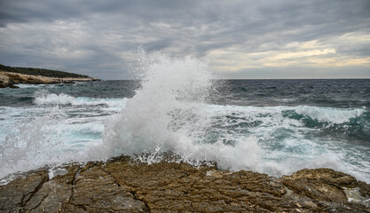 Waves break from the rock. Stormy sea. Waves crash on the shore. Rocky coast.