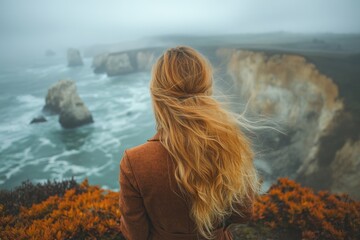 Coastal woman gazing at a misty ocean