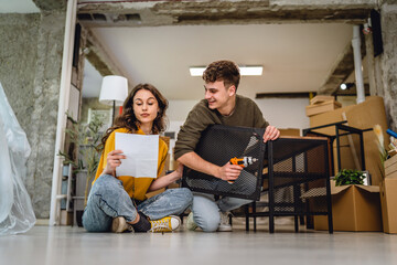 couple use electric screwdriver for assembling table at new apartment