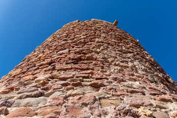 Upward View of Stone Watchtower Against Blue Sky