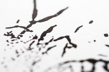 Extreme close up of black acrylic paint texture on paper. Selective focus.