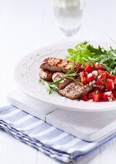 Fried pork tenderloin with tomato salsa. Bright background. Close up.	