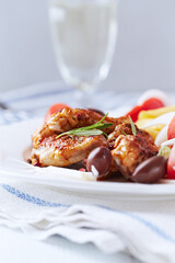 Spicy chicken wings with french fries and tomatoes. Close up.	
