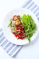 Fried pork tenderloin with tomato salsa. Bright background. Top view. 