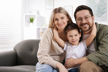 Portrait of happy family on sofa at home