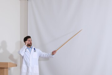 Doctor giving lecture in conference room with projection screen