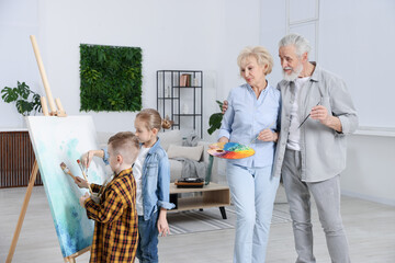 Grandparents and their grandkids painting together at home