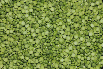Dried split green peas in a pile on white background