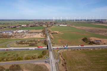 Blick auf Autobahn mit Bruecke in ländlicher Umgebung, Windpark am Horizont, Drohnenaufnahme, Brandenburg, Deutschland