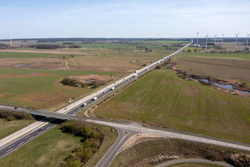Bruecke ueber die Autobahn mit Windpark am Horizont, Drohnenaufnahme, Brandenburg, Deutschland
