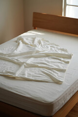 Cozy Bed with a Soft White Blanket: Serene and Comfortable Bedroom Scene