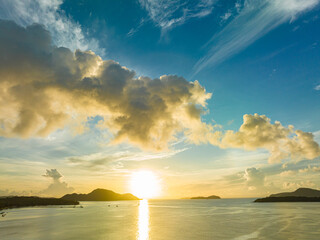 A vibrant tropical sunrise scene featuring colorful skies, serene waters, and  boats gently...