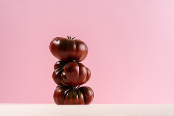 Vibrant arrangement of heirloom tomatoes on a soft pink backdrop
