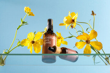 Moisturizing tonic bottles surrounded by vibrant yellow flowers in a serene setting