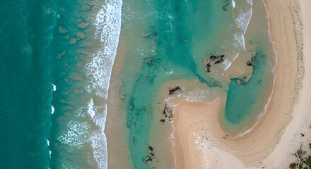 Aerial View of Waves Crashing on Sandy Beach Shoreline