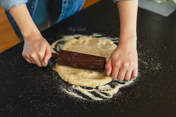 Cooking homemade pizza. Female hands making dough, adding sauce and ingredients.