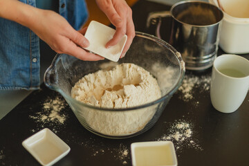 Cooking homemade pizza. Female hands making dough, adding sauce and ingredients.