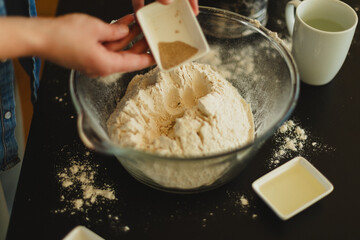Cooking homemade pizza. Female hands making dough, adding sauce and ingredients.