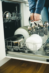 Built-in dishwasher in the kitchen, washing dishes. Plates, cups, glasses are worth washing. 