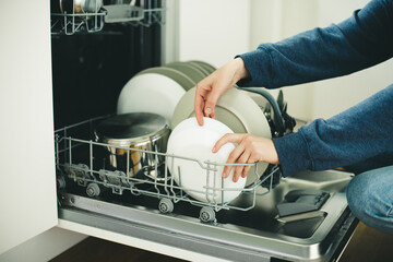 Built-in dishwasher in the kitchen, washing dishes. Plates, cups, glasses are worth washing. 