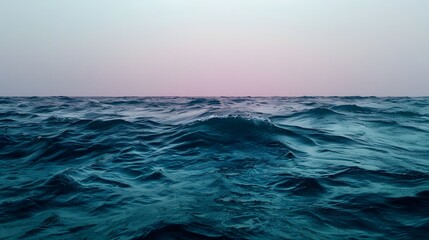 Obraz premium Calm Ocean Waves Under a Soft Pink Sky at Dusk in a Serene Natural Landscape