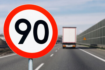 Speed limit 90 sign and cargo truck on highway. Logistic transport on asphalt road. Traffic...